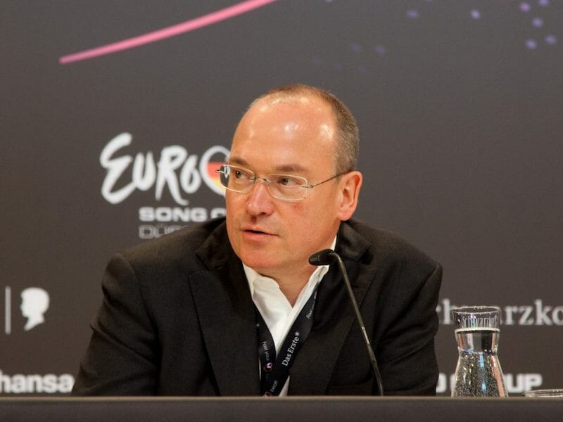 A man in a suit speaking at a podium.