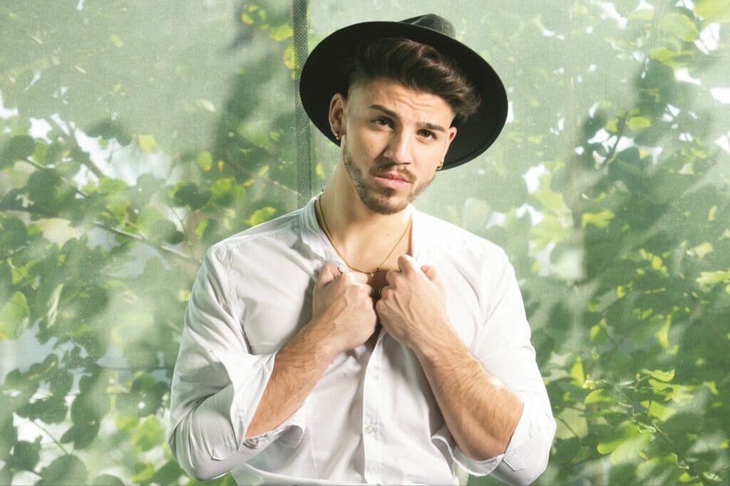 A man in a white shirt with a black hat and a black hat