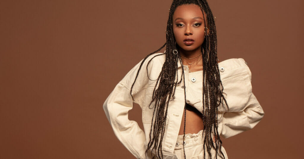 A woman posing on a brown background.